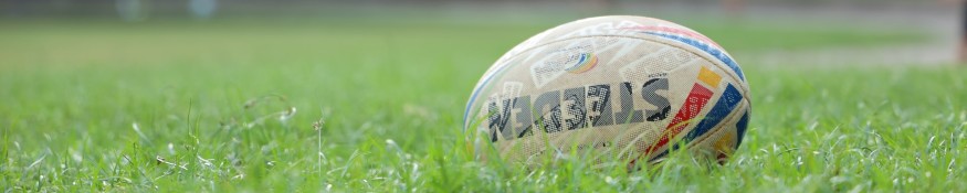 Rugby ball resting on grass.